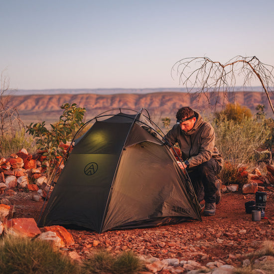 Backpacker setting up Alton's Lightweight Tent on hiking trail