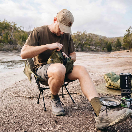 Hiker using Alton's Ultralight Camp Chair on outdoor trail
